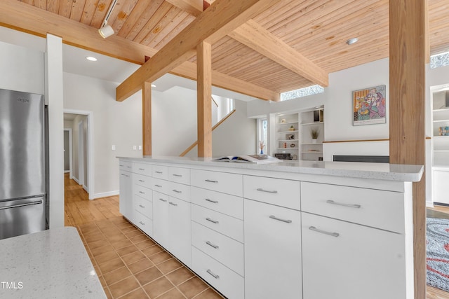 206 Spring Ln, Chapel Hill, NC 27514 - kitchen with a wood ceiling with exposed beams, modern cabinets, freestanding refrigerator, white cabinets, and light stone countertops