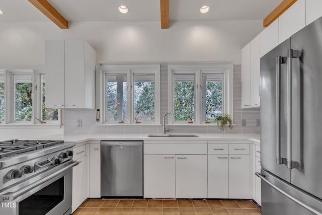 206 Spring Ln, Chapel Hill, NC 27514 - kitchen with high end appliances, beam ceiling, plenty of natural light, tasteful backsplash, and recessed lighting