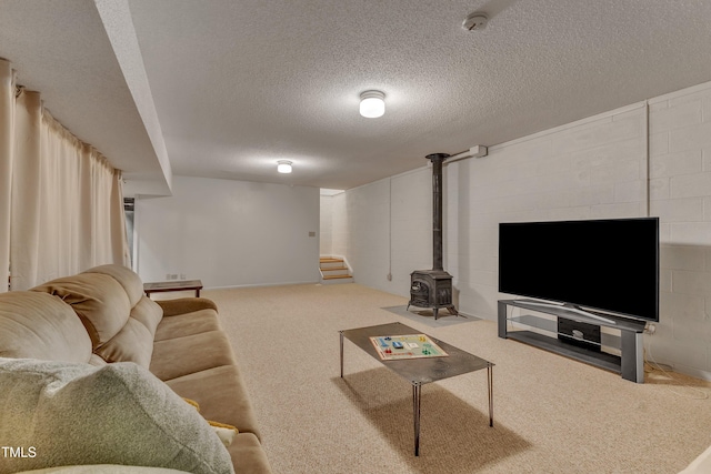 206 Spring Ln, Chapel Hill, NC 27514 - living room featuring a wood stove, a textured ceiling, carpet floors, stairway, and concrete block wall