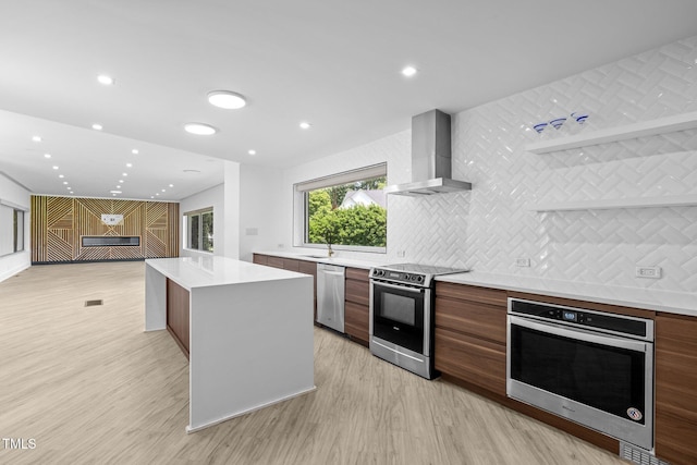 115 Ashworth Dr, Durham, NC 27707 - kitchen featuring wall chimney exhaust hood, modern cabinets, appliances with stainless steel finishes, light wood finished floors, and recessed lighting