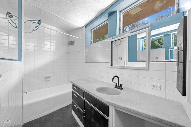 115 Ashworth Dr, Durham, NC 27707 - full bath featuring tile patterned flooring, tile walls, vanity, a textured ceiling, and backsplash