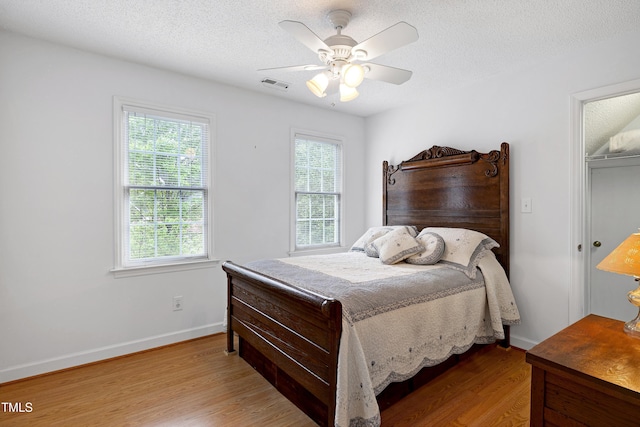 102 Whitlock Ln, Cary, NC 27513 - bedroom with multiple windows, wood finished floors, a textured ceiling, and a ceiling fan