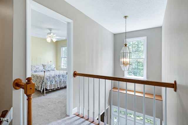 102 Whitlock Ln, Cary, NC 27513 - corridor featuring carpet, an upstairs landing, a chandelier, and a textured ceiling