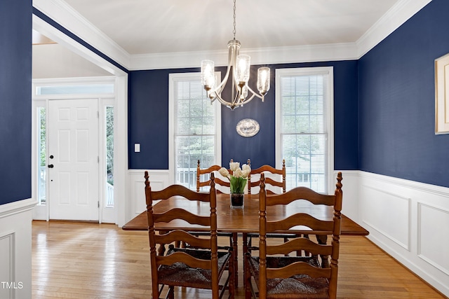 102 Whitlock Ln, Cary, NC 27513 - dining room with a chandelier, wainscoting, a decorative wall, light wood-type flooring, and ornamental molding