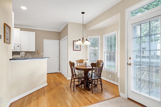 102 Whitlock Ln, Cary, NC 27513 - dining space with a chandelier, light wood finished floors, healthy amount of natural light, crown molding, and recessed lighting