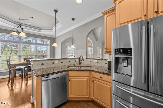 2011 Gibsonville Ossipee Rd, Elon, NC 27244 - kitchen featuring appliances with stainless steel finishes, dark wood-style flooring, a peninsula, dark stone countertops, and crown molding