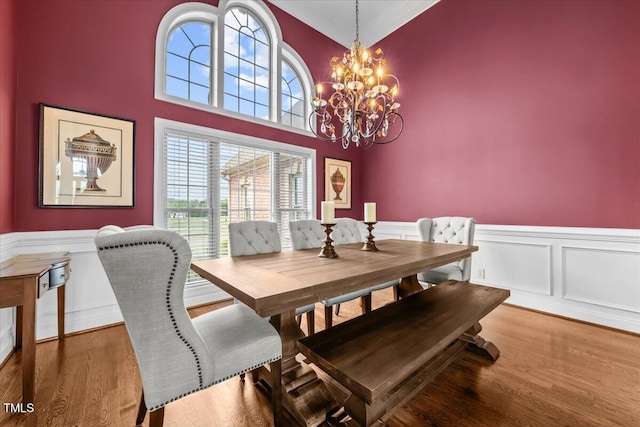 2011 Gibsonville Ossipee Rd, Elon, NC 27244 - dining area featuring a wainscoted wall, wood finished floors, a chandelier, and a decorative wall
