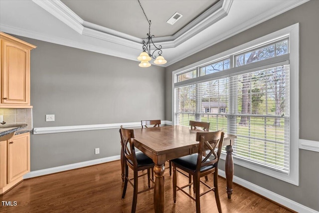 2011 Gibsonville Ossipee Rd, Elon, NC 27244 - dining space featuring dark wood finished floors, a tray ceiling, crown molding, and a chandelier