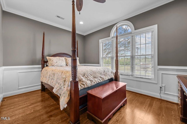 2011 Gibsonville Ossipee Rd, Elon, NC 27244 - bedroom featuring a wainscoted wall, wood finished floors, ornamental molding, recessed lighting, and a decorative wall