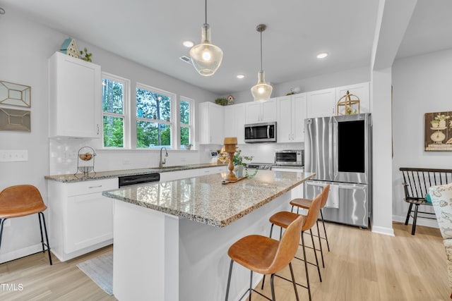 110 Gilder Woods Dr, Garner, NC 27529 - kitchen with appliances with stainless steel finishes, light wood-style floors, white cabinets, tasteful backsplash, and recessed lighting