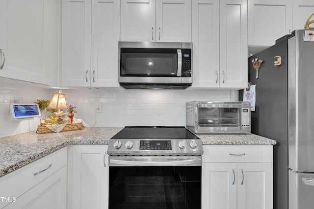 110 Gilder Woods Dr, Garner, NC 27529 - kitchen with stainless steel appliances, white cabinets, backsplash, and light stone countertops