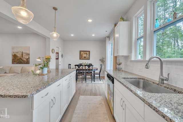 110 Gilder Woods Dr, Garner, NC 27529 - kitchen featuring healthy amount of natural light, white cabinets, hanging light fixtures, backsplash, and recessed lighting