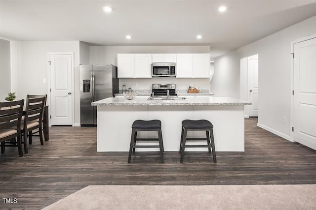 525 Camero Rift Trl, Wendell, NC 27591 - kitchen featuring appliances with stainless steel finishes, white cabinetry, recessed lighting, a kitchen island with sink, and a kitchen bar