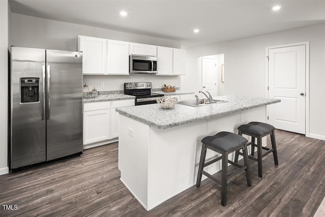525 Camero Rift Trl, Wendell, NC 27591 - kitchen with stainless steel appliances, white cabinets, dark wood-style flooring, a kitchen island with sink, and recessed lighting