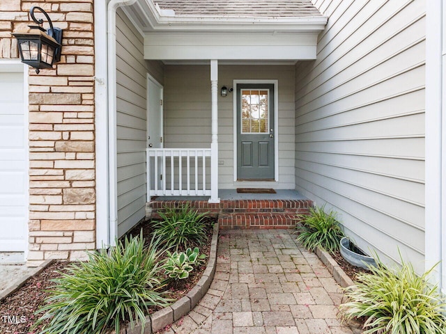 3525 Lytham Pl, Raleigh, NC 27604 - property entrance featuring a shingled roof, covered porch, stone siding, and an attached garage