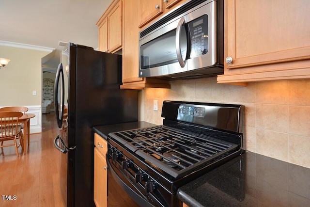 1079 Perdue Dr, Chapel Hill, NC 27517 - kitchen with black range with gas stovetop, stainless steel microwave, dark countertops, wood finished floors, and light brown cabinetry