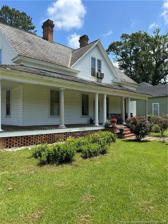 512 W Main St W, Rowland, NC 28383 - view of front of home featuring a chimney, covered porch, a front lawn, and roof with shingles