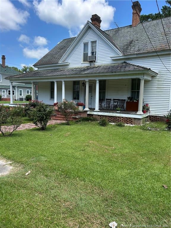 512 W Main St W, Rowland, NC 28383 - country-style home with a porch, a shingled roof, a front yard, and a chimney