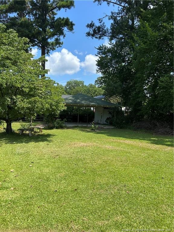 512 W Main St W, Rowland, NC 28383 - view of green lawn featuring an attached carport