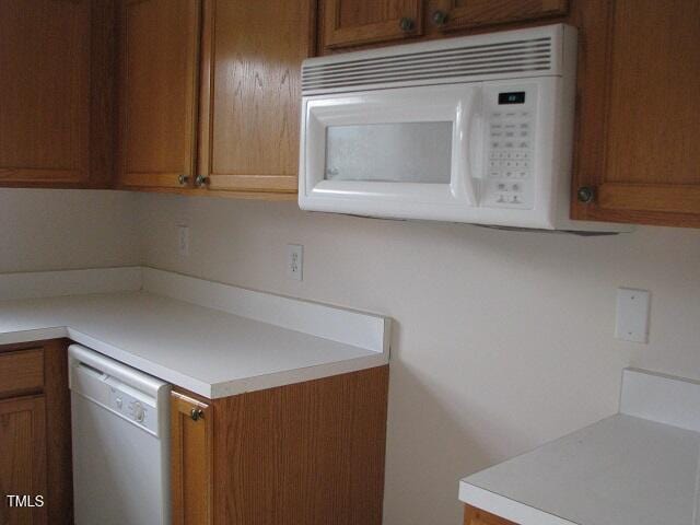 4419 Nightfall Ct, Durham, NC 27713 - kitchen with white appliances, light countertops, and brown cabinetry