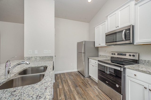 757 Frosty Way, Zebulon, NC 27597 - kitchen with stainless steel appliances, dark wood-style flooring, white cabinets, lofted ceiling, and light stone countertops