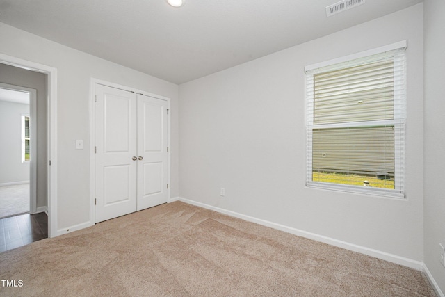 757 Frosty Way, Zebulon, NC 27597 - unfurnished bedroom with carpet flooring, multiple windows, and a closet
