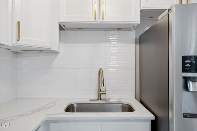2752 Weldon Ter, Durham, NC 27703 - kitchen featuring stainless steel fridge, white cabinets, backsplash, and light stone counters