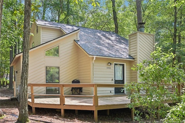 5905 Waters Edge Dr, Fayetteville, NC 28314 - rear view of house with a shingled roof, a wooden deck, and a chimney