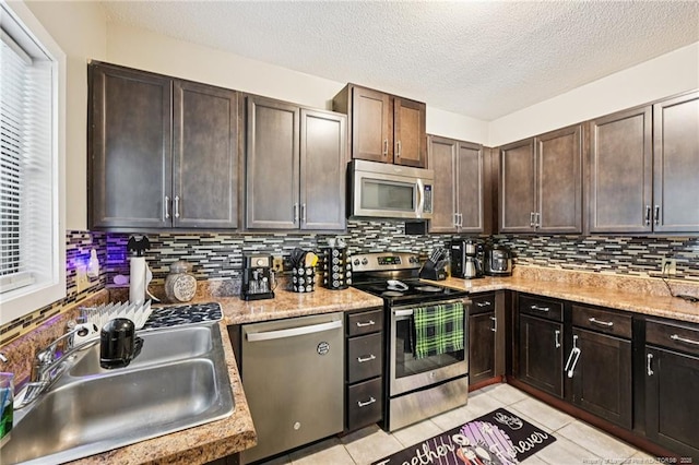 5905 Waters Edge Dr, Fayetteville, NC 28314 - kitchen featuring stainless steel appliances, tasteful backsplash, light countertops, light tile patterned flooring, and dark brown cabinetry