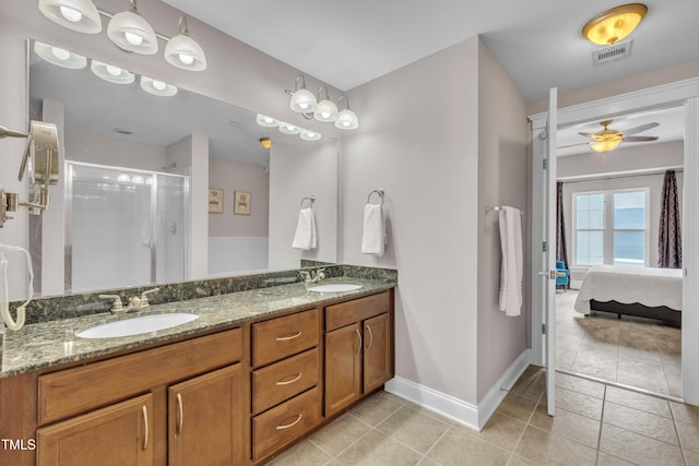 222 Glenwood Ave # 416, Raleigh, NC 27603 - ensuite bathroom featuring tile patterned floors, double vanity, a ceiling fan, and a stall shower