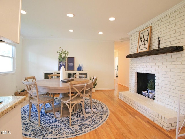 503 N Glen Dr, Raleigh, NC 27609 - dining space with crown molding, light wood finished floors, recessed lighting, and a brick fireplace