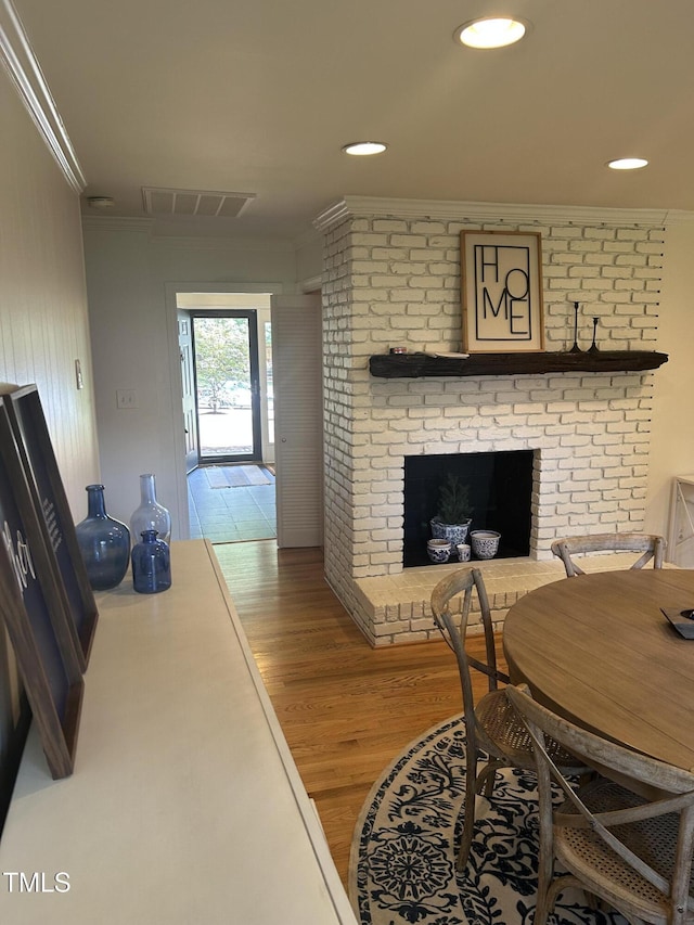 503 N Glen Dr, Raleigh, NC 27609 - dining room featuring ornamental molding, wood finished floors, a fireplace, and recessed lighting