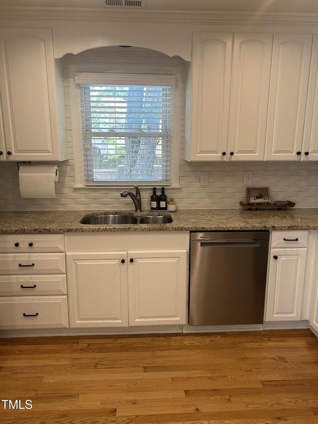 503 N Glen Dr, Raleigh, NC 27609 - kitchen with white cabinets, tasteful backsplash, stainless steel dishwasher, light stone counters, and light wood-type flooring