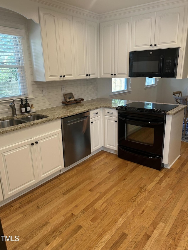 503 N Glen Dr, Raleigh, NC 27609 - kitchen with black appliances, white cabinetry, light wood-type flooring, and healthy amount of natural light