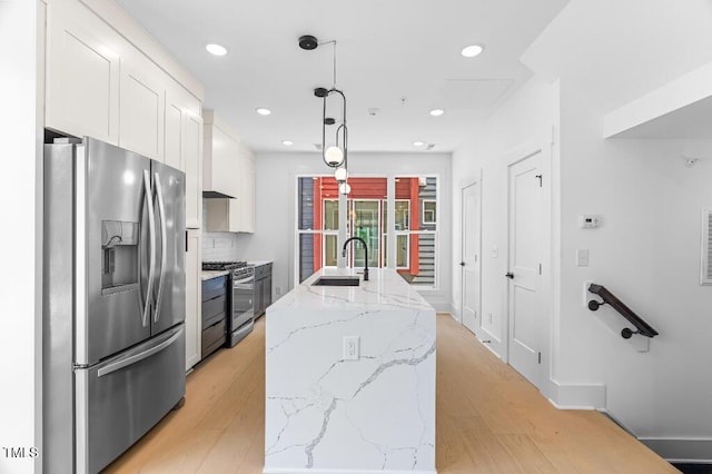 2 Seawell Ave Unit 101, Raleigh, NC 27601 - kitchen with appliances with stainless steel finishes, white cabinets, light wood-type flooring, pendant lighting, and a center island with sink