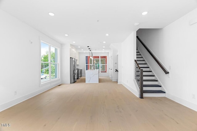 2 Seawell Ave Unit 101, Raleigh, NC 27601 - unfurnished living room featuring stairway, light wood-style flooring, and recessed lighting