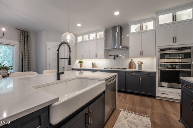249 Dona Dr, Carthage, NC 28327 - kitchen with light countertops, white cabinets, appliances with stainless steel finishes, wall chimney range hood, and decorative light fixtures