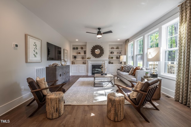 249 Dona Dr, Carthage, NC 28327 - living area featuring ceiling fan, dark wood-style flooring, a glass covered fireplace, built in shelves, and recessed lighting
