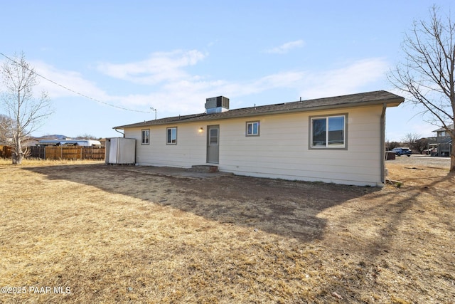 back of house with a yard and central AC