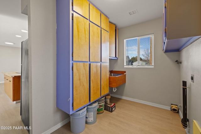 laundry area with cabinets, washer hookup, light wood-type flooring, and electric dryer hookup