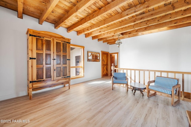living area featuring wood ceiling, wood finished floors, beamed ceiling, and baseboards