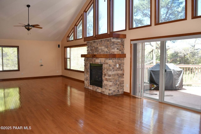 1284 Mcdonald Dr, Prescott, AZ 86303 - unfurnished living room with high vaulted ceiling, ceiling fan, wood finished floors, and a stone fireplace