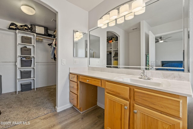 bathroom featuring ceiling fan, vanity, and wood-type flooring