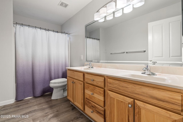 bathroom featuring toilet, vanity, and hardwood / wood-style flooring