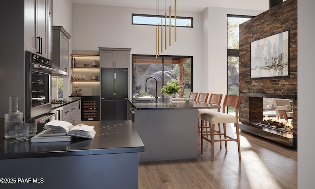 4333 N Twisted Trl, Prescott, AZ 86301 - kitchen featuring dark countertops, stainless steel oven, a towering ceiling, light wood-style flooring, and beverage cooler