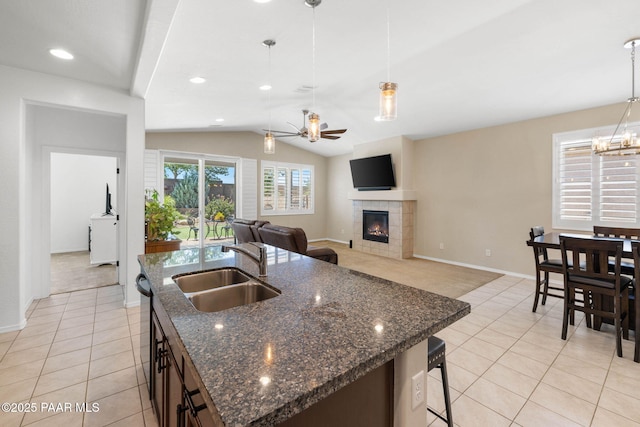 6214 Harvest Moon Ave, Prescott, AZ 86305 - kitchen with light tile patterned floors, a fireplace, ceiling fan, lofted ceiling, and hanging light fixtures