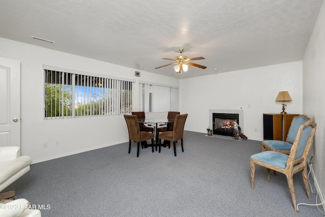 dining area with carpet flooring, ceiling fan, and a textured ceiling