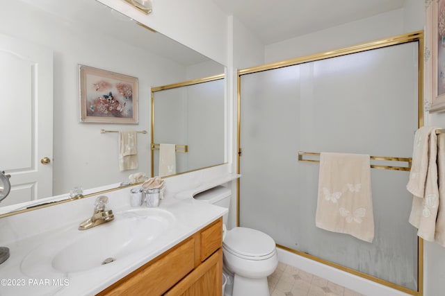 bathroom with vanity, toilet, and a shower with shower door