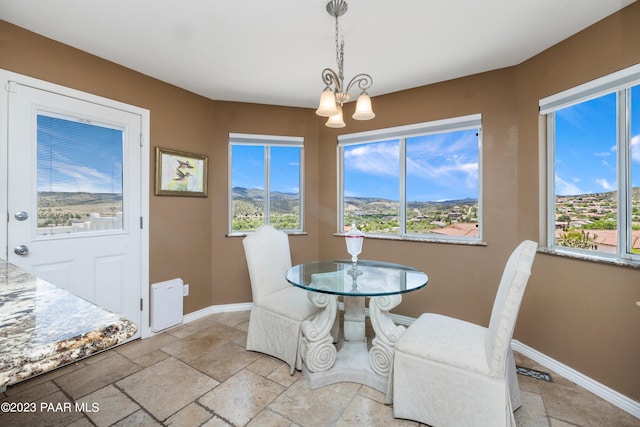 dining space featuring a chandelier, a mountain view, and a healthy amount of sunlight