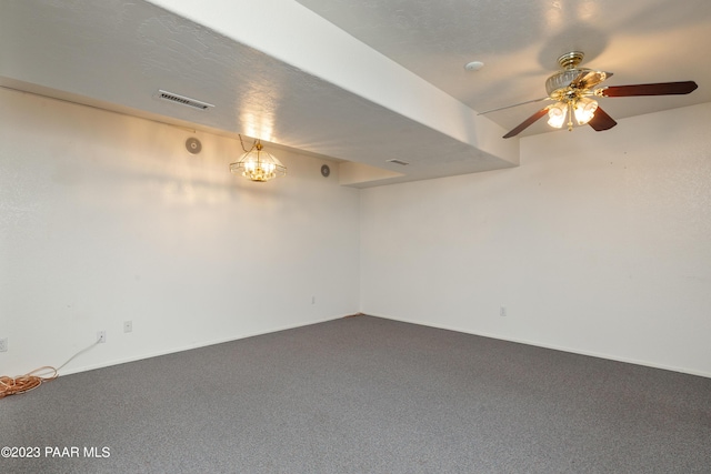 basement featuring carpet flooring and ceiling fan with notable chandelier